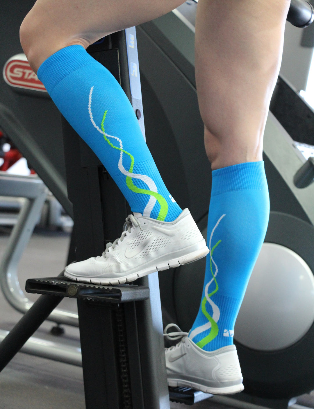 Woman using Stairmaster while wearing over the calf compression socks.