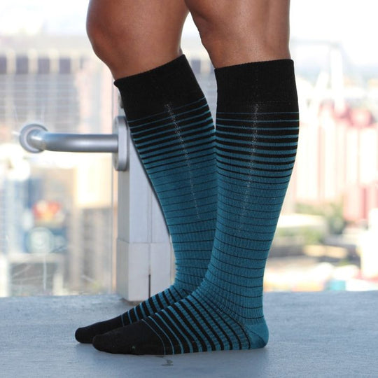 Athlete relaxing in their Sox Solution over the calf socks in stripes.