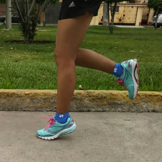 Woman athlete running using VitalSox performance socks.
